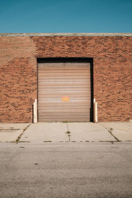 Brick warehouse with a closed roller garage door.