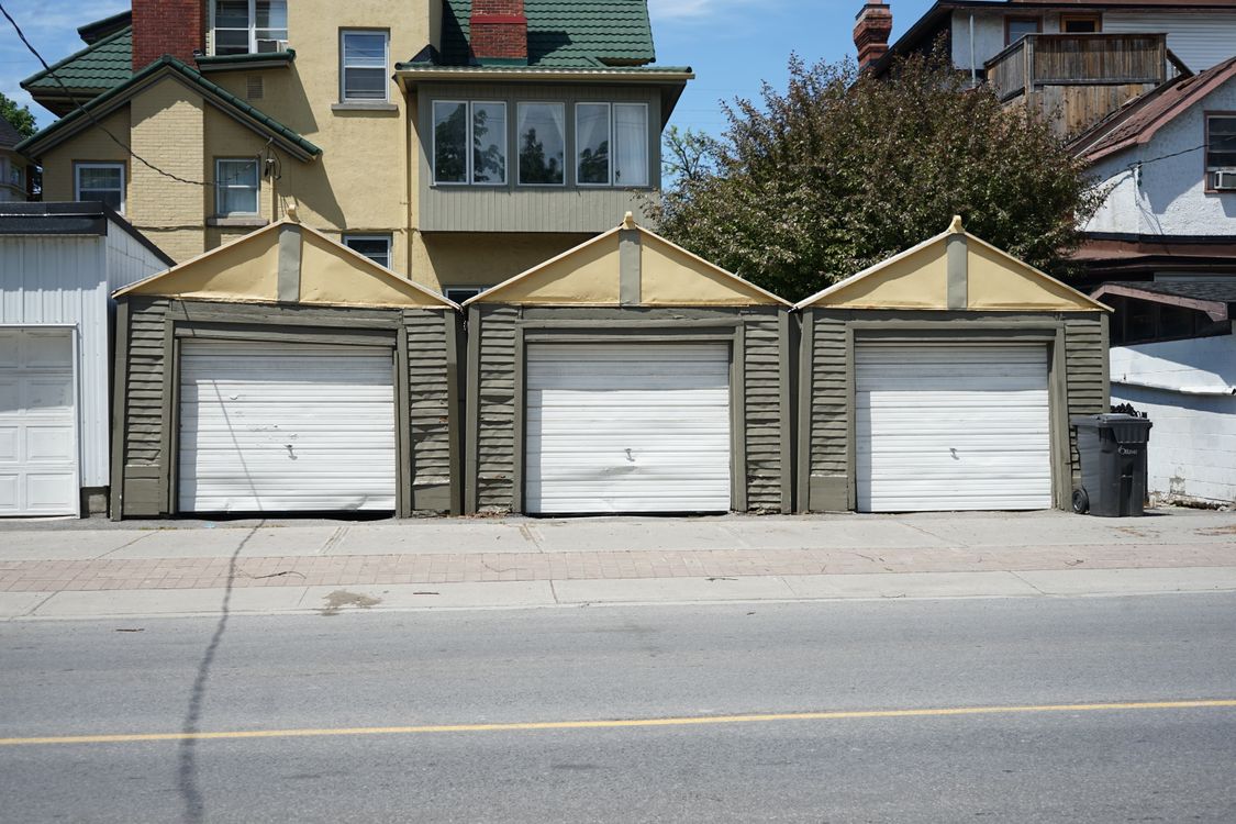 Row of traditional residential garage doors on a sunny day.