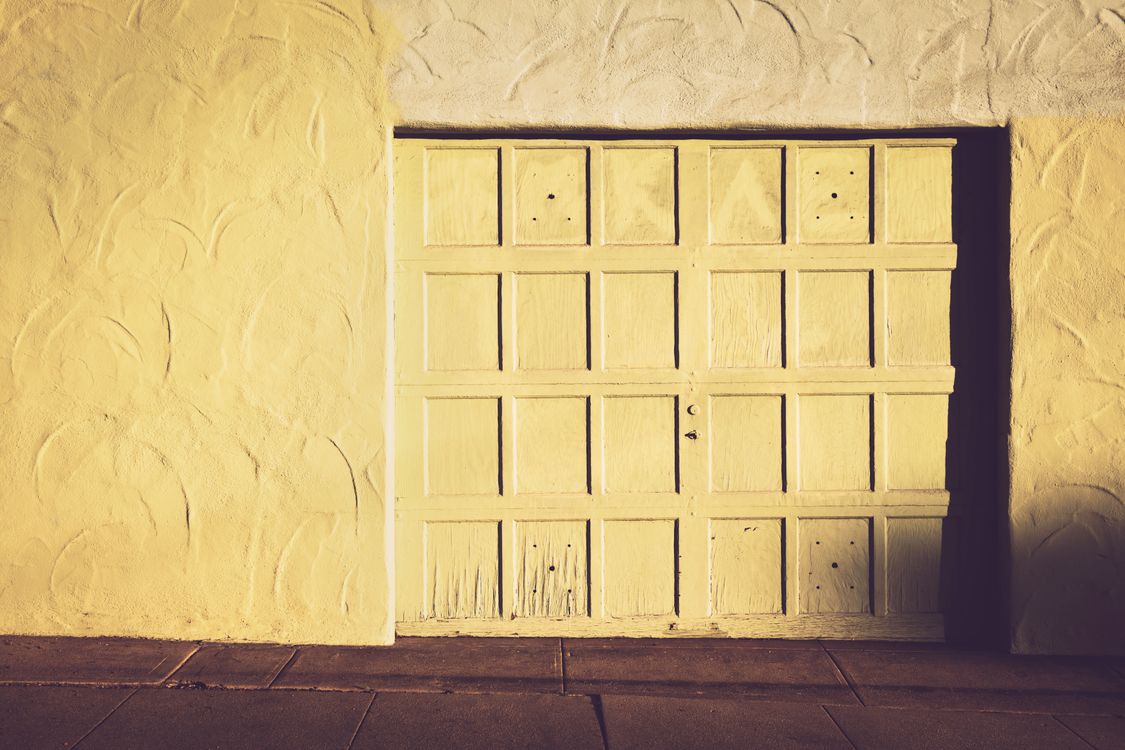Vintage wooden garage door set against a textured wall.
