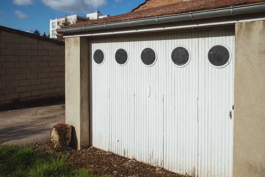 White residential garage door with decorative circular windows.